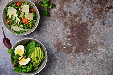 Two fresh salads bowls isolated on dark background. Flat lay salad bowls