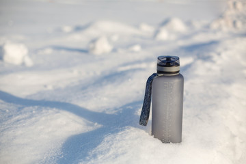 Grey spotive plastic drink bottle in snow