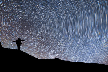 Wall Mural - beautiful starry night, female silhouette a standing with raised up arms on the mountain . night lan
