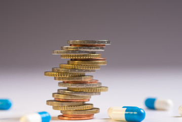 Coins are placed among themselves in different positions next to the blue and white pills.