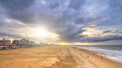 Wall Mural - Beautiful seaside landscape - view of the beach near the embankment of The Hague with people making promenade, the Netherlands