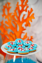 Big White Plate With A Lot Of Ginger Bread Cookies With Bright Blue Icing And Sea Time Décor. Orange Wooden Corals On The Background