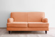 © New Africa - Orange sofa in living room near white wall