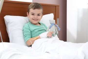 Wall Mural - Little child with intravenous drip and toy in hospital bed