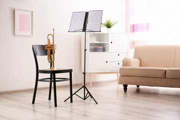 Poster - Trumpet, chair and note stand with music sheets in room