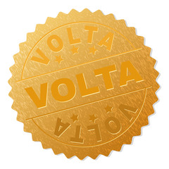 VOLTA gold stamp award. Vector gold award with VOLTA text. Text labels are placed between parallel lines and on circle. Golden surface has metallic texture.