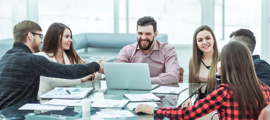 handshake financial partners and business team in the workplace