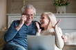 © fizkes - Spouses sitting on couch feels happy received great news online