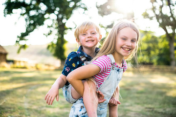 girl giving her brother a piggyback ride