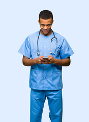 Canvas Print - Surgeon doctor man sending a message with the mobile on isolated background