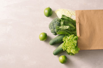 Fresh and juicy raw vegetables in a paper shopping back. White background.