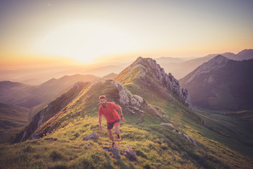 Wall Mural - man trail running on a mountain at the dask