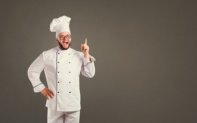 Wall Mural - Funny cheerful chef in white uniform on background for text.