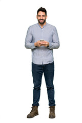 Wall Mural - Full-length shot of Elegant man with shirt sending a message with the mobile on isolated white background