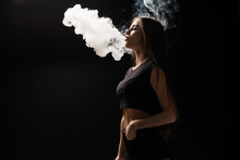 Young Woman Smoking Electronic Cigarette Vape On Black Background