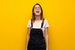 © luismolinero - Woman over yellow wall shouting to the front with mouth wide open