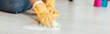 Cropped view of woman in yellow rubber gloves cleaning floor with rag