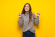 © luismolinero - Young woman over yellow wall pointing with the index finger a great idea