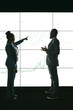 © JonoErasmus - Silhouette of a black african business people giving a presentation conference. Pointing at a large video screen with charts and graphs next to her in a dark room