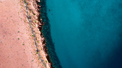 Wall Mural - Sand, rock, and sea patterns on cristal clear waters.