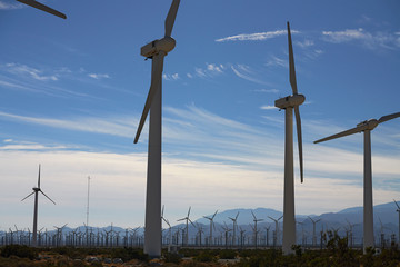 Wind park with many wind turbines in California landscape with mountains and desert plains