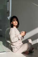 Wall Mural - Beautiful young woman drinking coffee