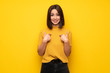 © luismolinero - Young woman over yellow wall with surprise facial expression