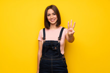 Young Woman Over Yellow Wall Happy And Counting Three With Fingers