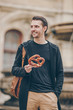 © travnikovstudio - Beautiful young man holding pretzel and relaxing in park