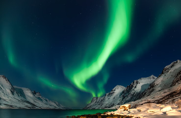 amazing aurora borealis in north norway (kvaloya), mountains in the background