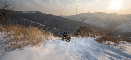 Wall Mural - sniper, soldier with a gun hiding in the bushes, winter