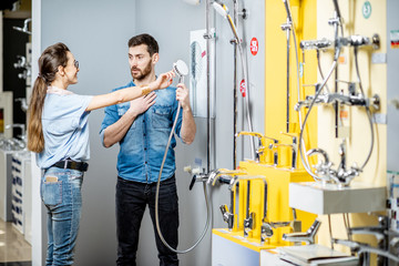 Wall Mural - Couple choosing shower faucet in the shop