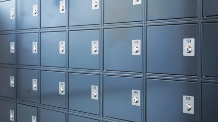 Metallic modern mailboxes lockers in gray-blue colors in a row at the entrance of a business center or at the entrance to a residential building