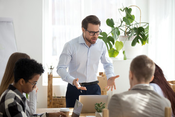 Wall Mural - Angry manager boss shouting at group office meeting scolding employees