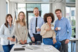 © nenadaksic - Cheerful group of business people posing in office. Multicultural group. Start up business concept.