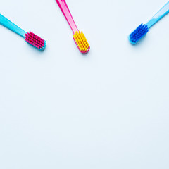 Wall Mural - Colorful tooth brushes with bright color bristles on a light pastel blue background. Dental tools with empty space for text for  your mockup.