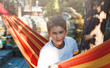 © Natali - Cute young cheerful boy in white t shirt  lies on hammock outdoor, rests at vacation concept. Summer, holidays