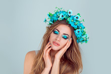 Beautiful Young Woman Smiling Model With Flowers On Head Floral Headband Hairstyle Makeup Blue Green Eye-shadow Posing With Closed Eyes Isolated On Light Blue Background. Spring Hippie Bride Concept