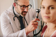 © Jacob Lund - ENT doctor checking ear with otoscope of woman patient