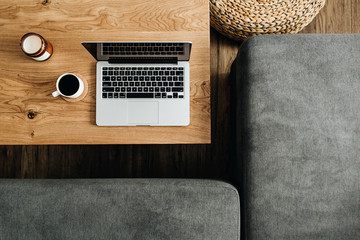 Wall Mural - Top view of laptop, coffee cup and candle on wooden table. Blogger / freelancer home office workspace flatlay. Modern nordic interior design concept.