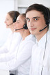 © rogerphoto - Call center operators at work. Focus at young man in headset