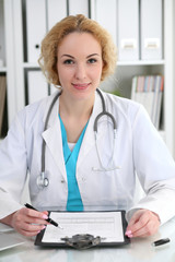 Wall Mural - Doctor woman at work. Physician filling up medical history records form at the desk. Medicine, healthcare  concept