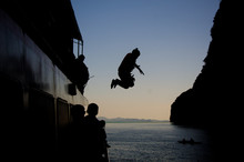 Young Teen Boy With Extreme Adrenaline Sport Jumping From A Ferry Ship To The Ocean Sea Water To Swim, Dive And Snorkel