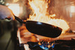 Chef steering flamed frying pan