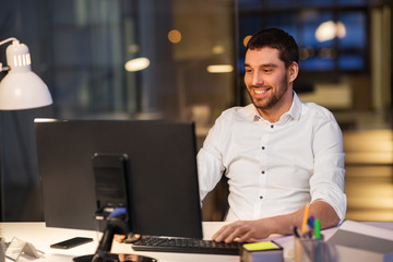 Wall Mural - business, overwork, deadline and people concept - happy businessman with computer working at night o