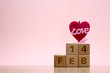 © Hopeful Studio - Wooden blocks of date 14 Feb for February on pink background with heart and word LOVE. Love and valentine's day concept