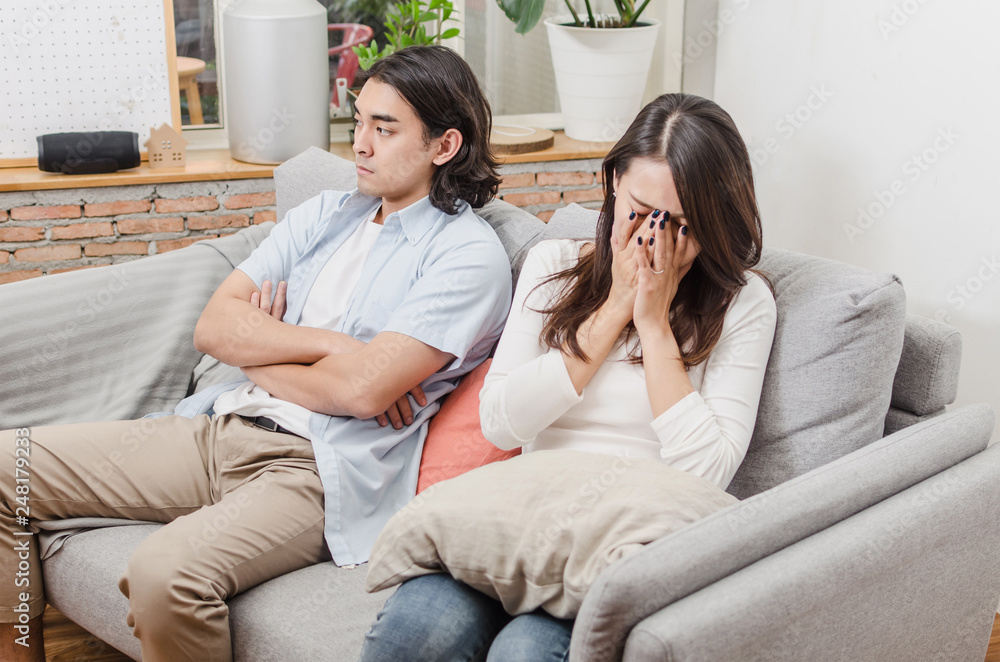 sadness young asian wife having quarrel and sitting on sofa after fight ...