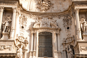 Part of facade of catholic cathedral  with statue in Murcia, Spain.Architecture of baroque and renaissance style.