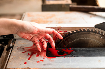 Hand and circular saw disc bloody on white background