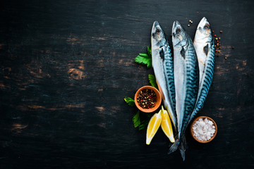 Wall Mural - Fish. Raw Mackerel on a black wooden background. Top view. Free copy space.